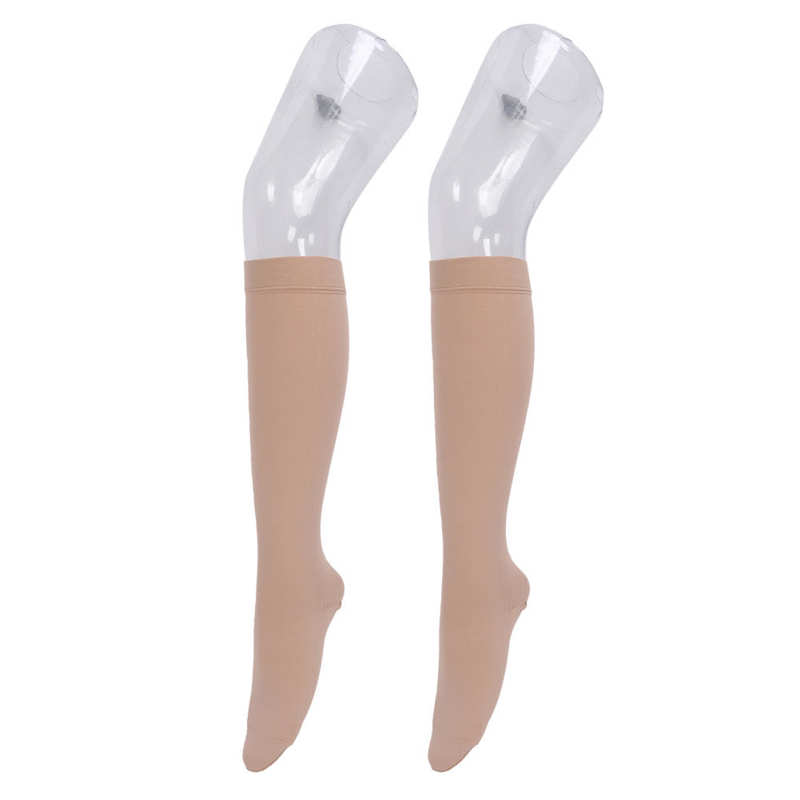 deux fausses jambes en plastiques portant deschaussettes compression orthopédiques femme sur fond blanc