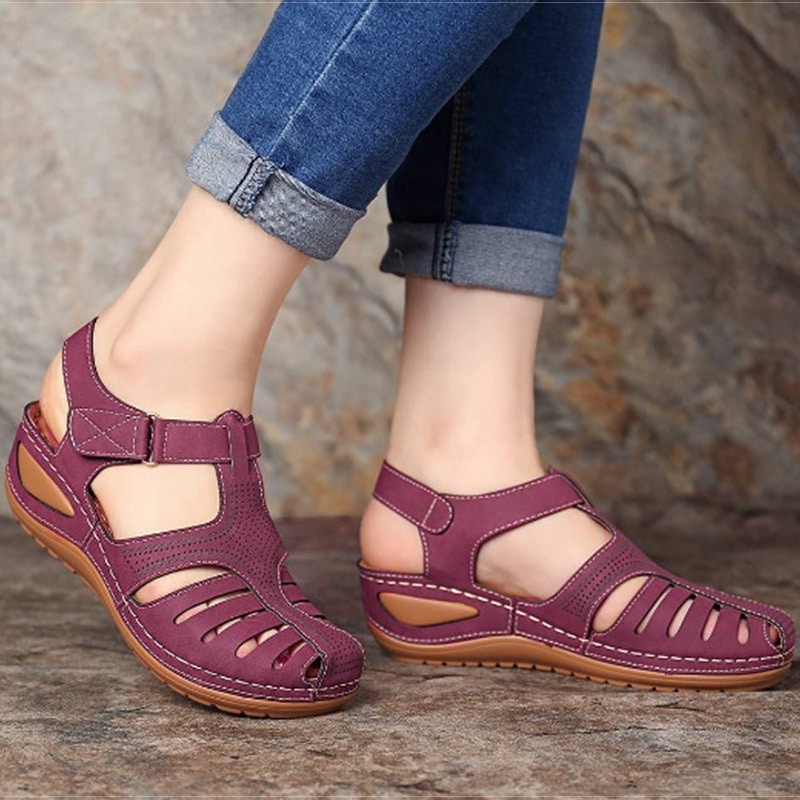 Photo de sandales orthopédiques violettes à talons portées par une femme avec un jean
