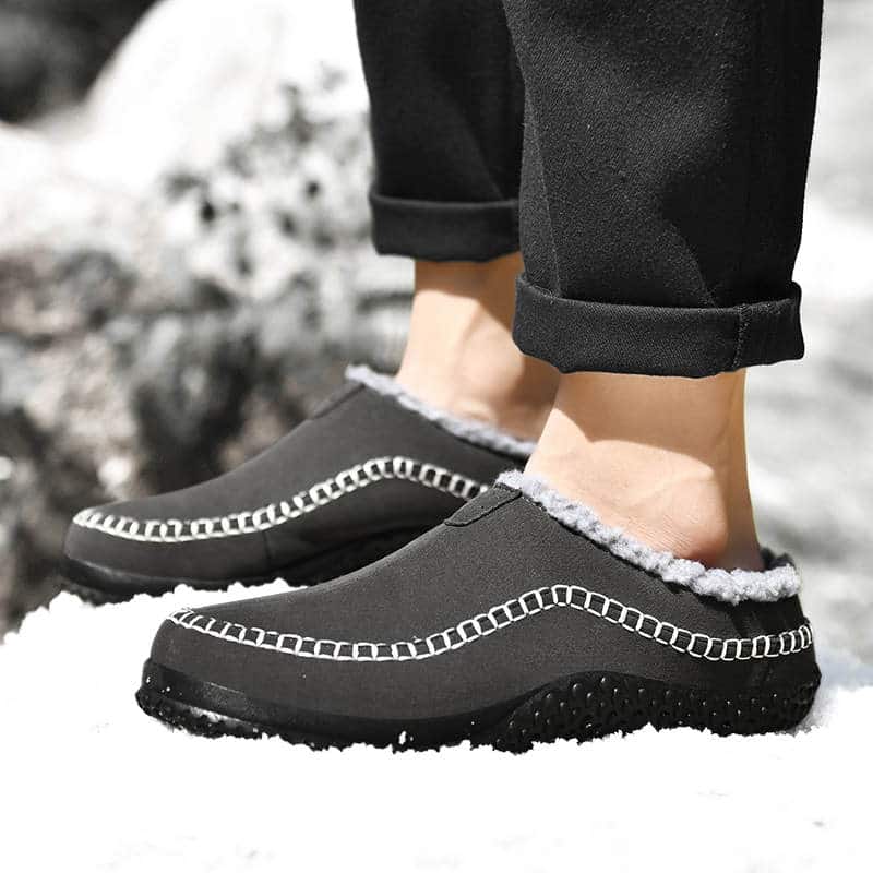 Hommes qui porte des chaussons orthopédique noire dans le neige