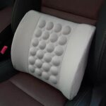 Coussin orthopédique lombaire à vibrations blanc posé sur une siège de voiture